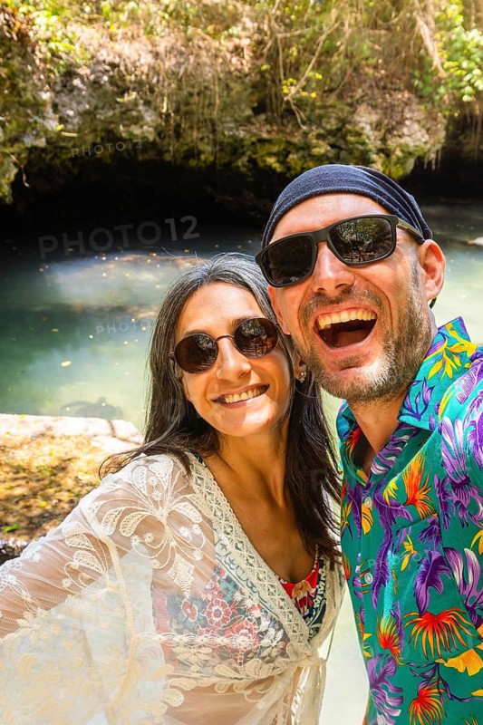 Portrait selfie couple man woman travelers wear vibrant tropical shirt takes pose in Baraka Natural Aquarium. Concept joy, fun and freedom sightseeing secluded Zanzibar turtle sanctuary
