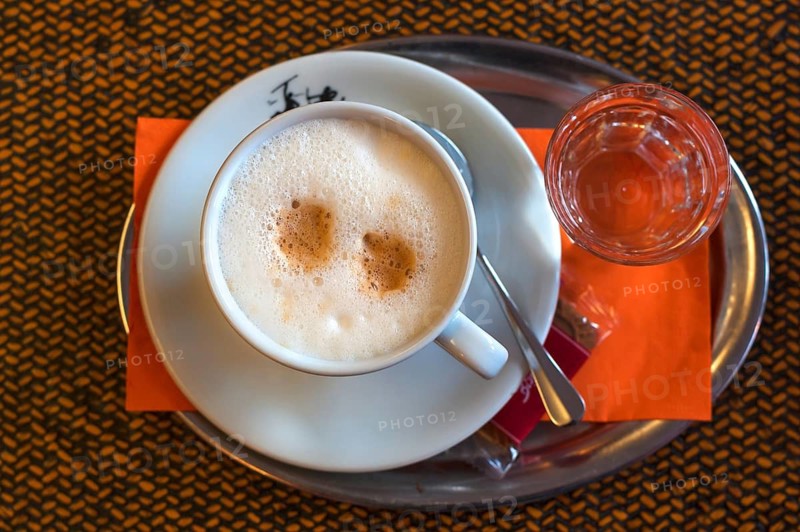 Cappuccino with a glass of water on a tray, Germany