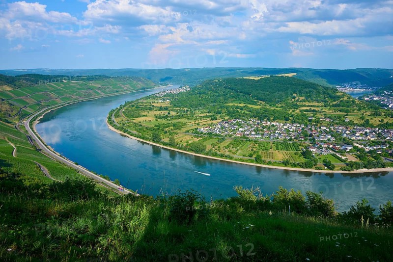 Picturesque river landscape with vineyards and village under blue sky with clouds, Rheinschleife, Rhine, Boppard, Rheingau, Hesse, Germany