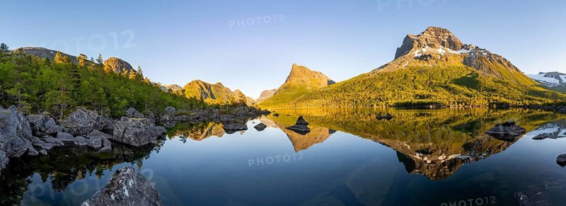 Picturesque mountain landscape with Innerdalstårnet peak in the Innerdalen high valley, mountain peaks reflected in Lake Innerdalsvatna, in the evening light at sunset, Trollheimen Mountain Area, Sunndal, Møre og Romsdal, Norway