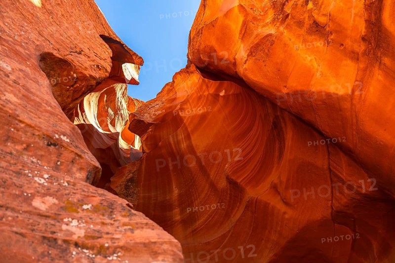 Antelope canyon's vibrant red orange navajo sandstone walls display flowing, wave like shapes and textures, sculptured over time by water and wind, creating a beautiful natural landmark