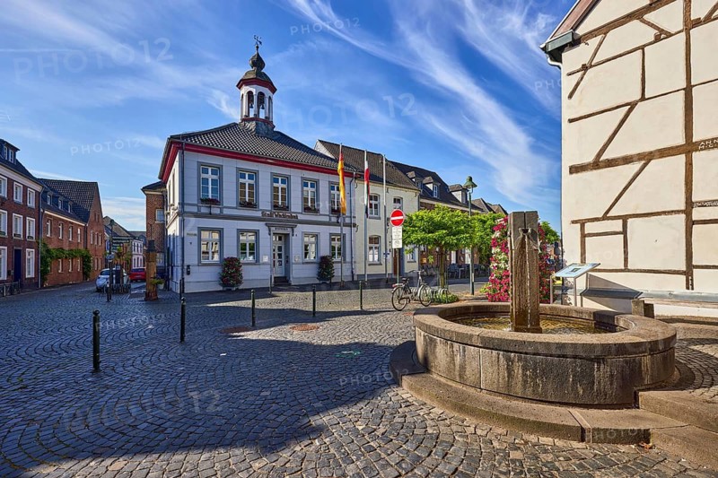 Town hall, historic building, half-timbered house, old town center, fountain, barrier bollard, roadway, paving stones, tree, blue sky, cirrus clouds, cirrostratus clouds, intersection of Weinstraße, Feldstraße and Mühlenstraße, Wachtendonk, Kleve district, North Rhine-Westphalia, Germany