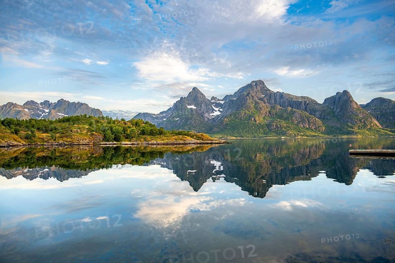 Mountains are reflected in the water in a bay on Raftsund fjord, Vesterålen, Norway