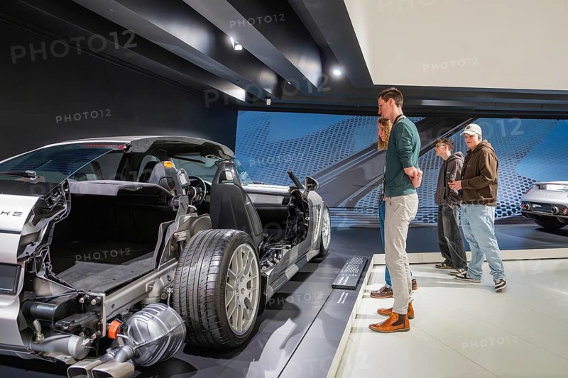 Visitors look at a partially dismantled car in the museum exhibition room, Porsche Museum, Stuttgart, Germany