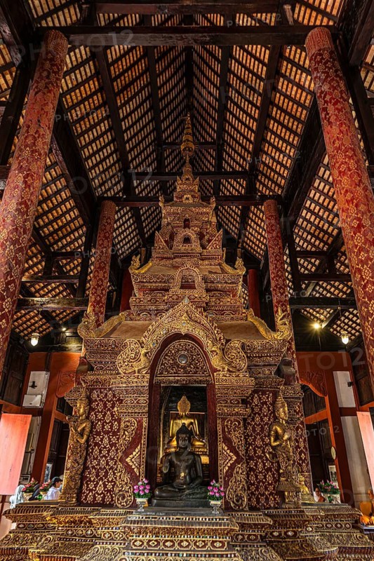 Bronze Buddha statue in a public prayer hall in the Wat Phra Singh Buddhist temple complex, Chiang Mai Old City Center, Chiang Mai Province, Thailand