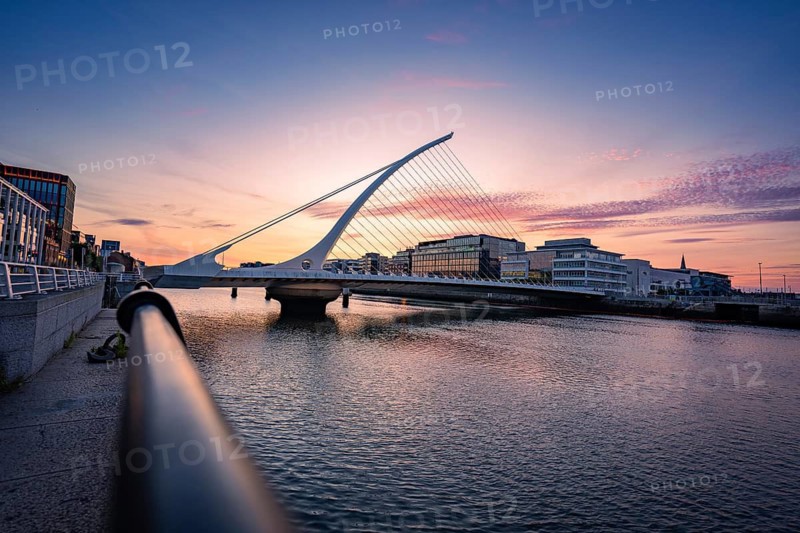 Samuel Beckett Brg, bridge over a river at dusk surrounded by urban architecture and colorful skies, Dublin, Ireland