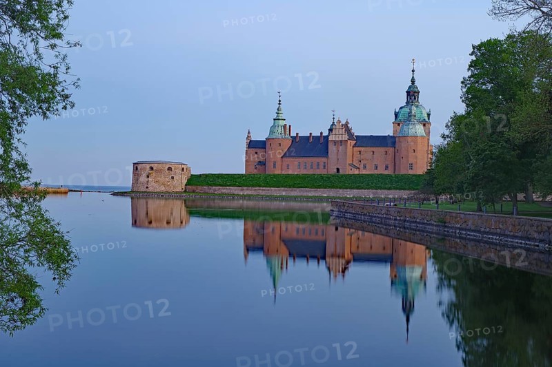 A castle with calm water at dusk, surrounded by lush green spaces and nature, Kalmar Slott, Kalmar, Smaland, Sweden