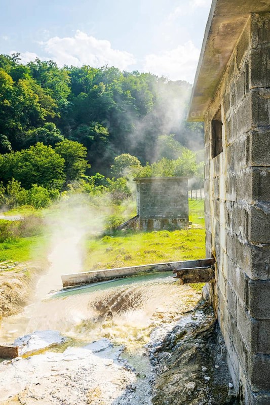 Close up of steaming hot springs in sunny summer day in picturesque georgian landscape in background. Georgia