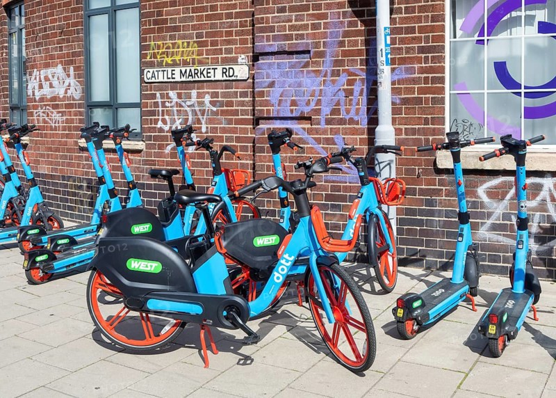 Public rental electric vehicles WEST e-bikes and e-scooters operated by micromobility company Dott, Cattle Market Road, Bristol, England, UK