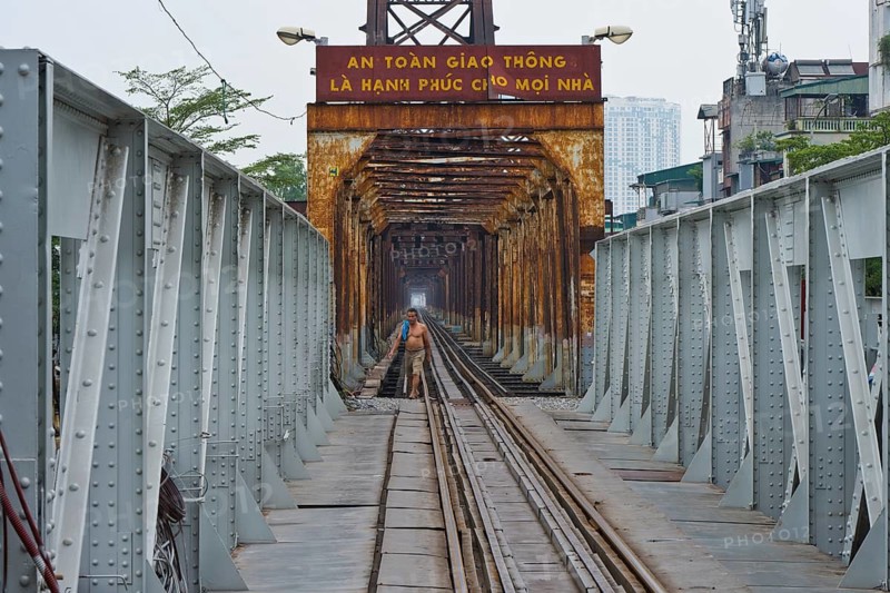 Vietnamese man walks across the tracks of the Long Bien railway bridge across the Red River, Hanoi, Ha Noi province, Vietnam