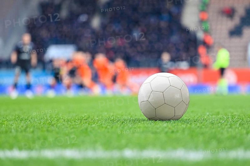 Ball on the football field and players in the background during match at the stadium in Lubin, Poland