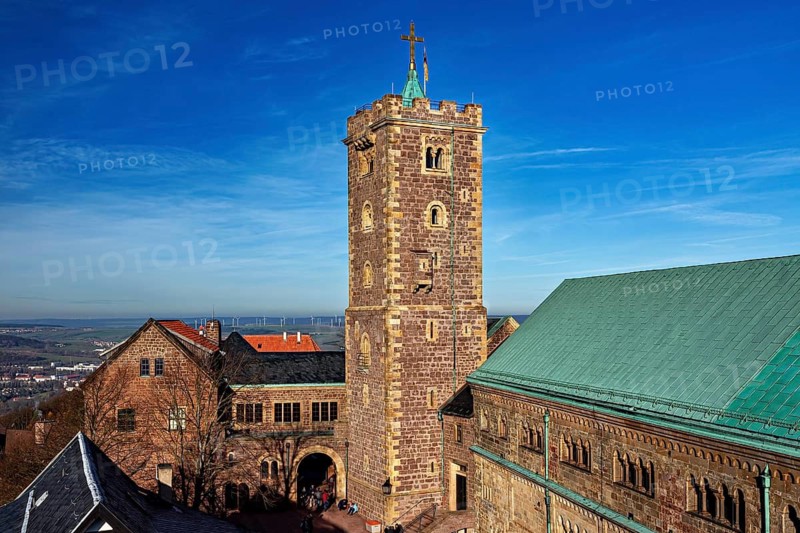 Castle ensemble with a high tower and several buildings with green roofs under a blue sky, The Wartburg near Eisenach in Thuringia
