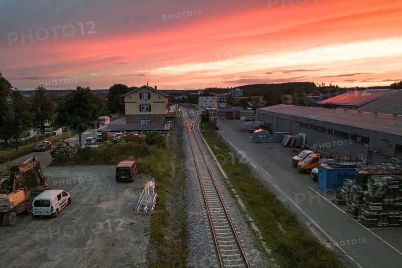 Industrial environment with parking lots and tracks under a spectacular orange sky at sunset, Hermann Hesse Bahn, Althengstett, Calw district, Germany
