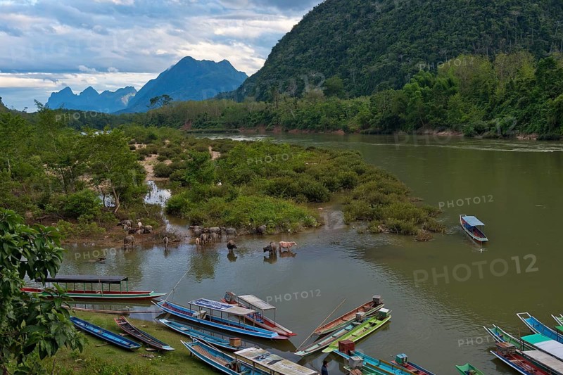 Mountain landscape near the village of Muang Ngoi on the Nam Ou River with water buffaloes and longboats, Phongsali province, Laos