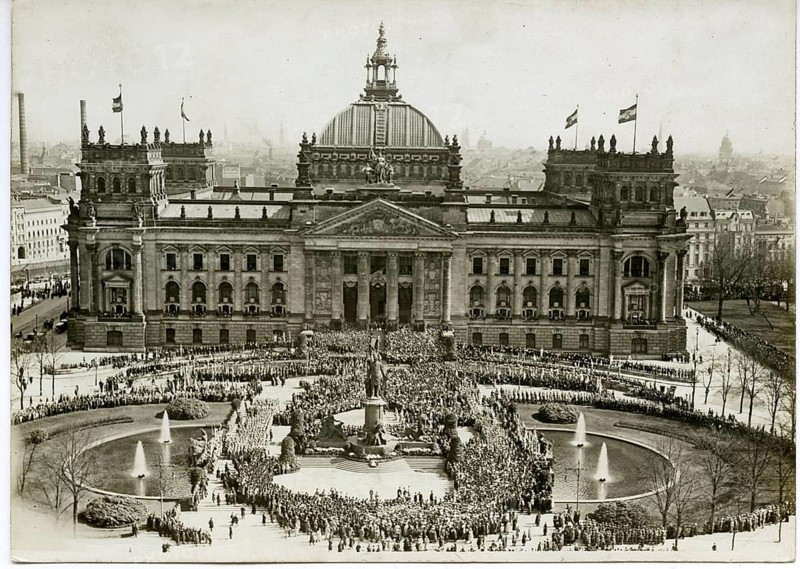 Reichstag, Berlin, public holiday, historic building with dome surrounded by crowds, fountains and waving flags in black and white, around 1920