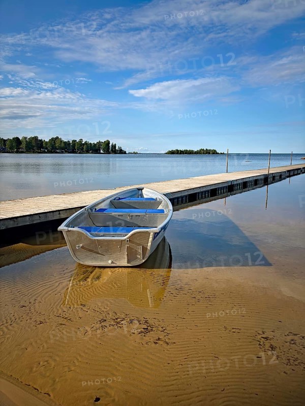 Metal boat on a sandy beach next to a long jetty. Quiet and clear atmosphere, Vänern, Mellerud, Dalsland, Sweden