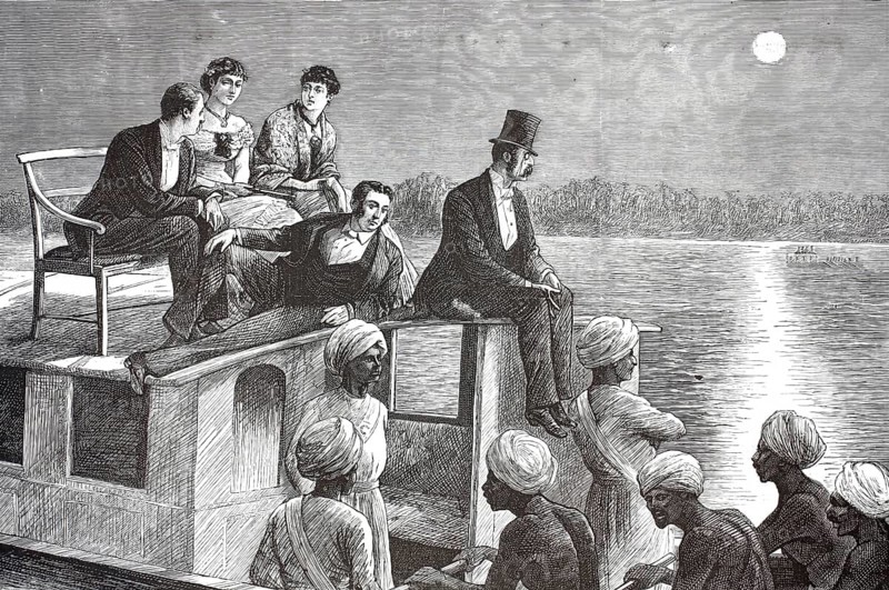 European colonial rulers and their Indian servants on a boat in Cochin, India. A group of European colonial rulers and finely dressed ladies sit elevated on the roof of a river boat. In contrast, there are the Indian rowers with turbans at the bottom, which propel the boat forward at night, 1882, illustration, reproduction from a model from the 19th century. Authentic, file restored for optimal use, exact date of submission unknown, historical
