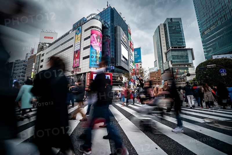 Crowd crossing zebra crossing on a large intersection, motion blur, back modern houses with colorful neon signs, long exposure, Shibuya Crossing, Shibuya, Tokyo, Japan