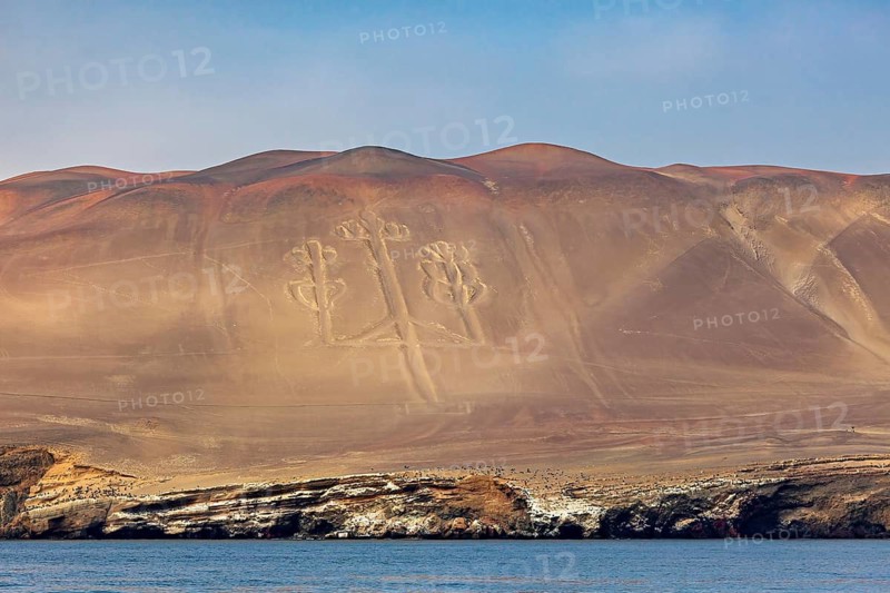 Geoglyph in the shape of a candelabra on sand dunes off a coast, candelabra of Paracas in Peru