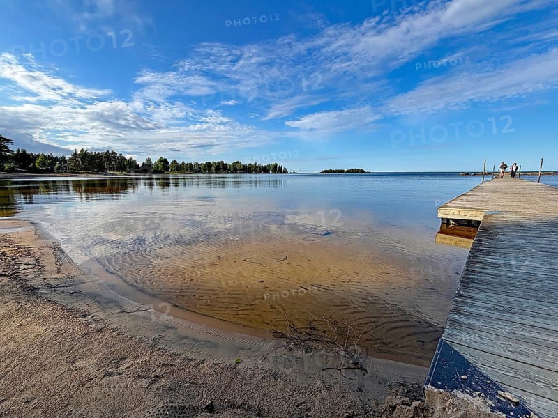 Jetty on a sandy beach with clear water and blue skies. Quiet summer atmosphere, Vänern, Mellerud, Dalsland, Sweden