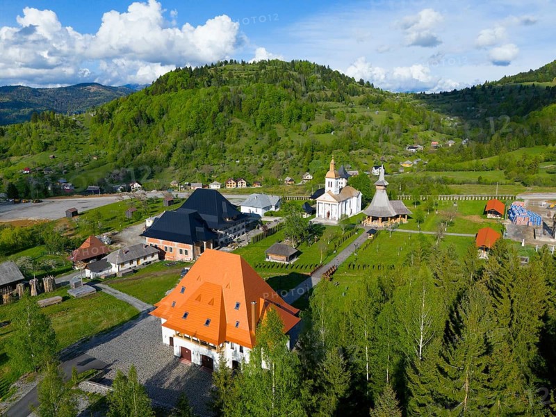 Historic buildings and churches in a green hill and forest landscape in sunny weather, aerial view, Manastirea Adormirea Maicii Domnului, Izvorul Negru, Moisei monastery, Maramure?, Maramures, Maramures, Maramures region, Romania