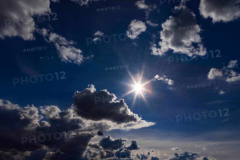 Onne glows between cumulus clouds, dramatic cloudy sky, Austria