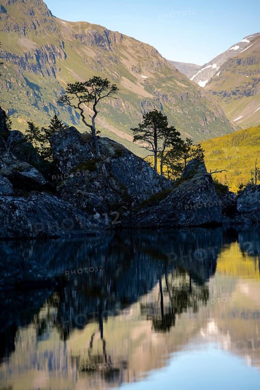 Picturesque mountain landscape in the Innerdalen high valley, silhouettes in front of mountain peaks, reflection in Lake Innerdalsvatna, Trollheimen Mountain Area, Sunndal, Møre og Romsdal, Norway