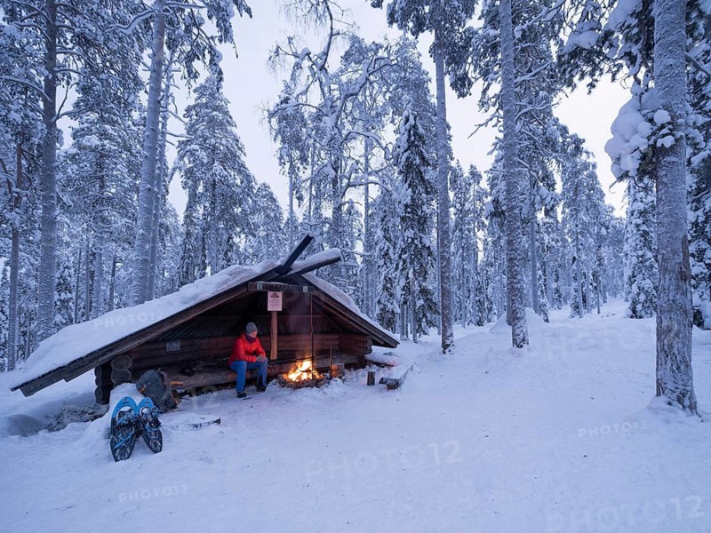 Rest at a fireplace, snowshoe hike. Luosto, Lapland, Finland
