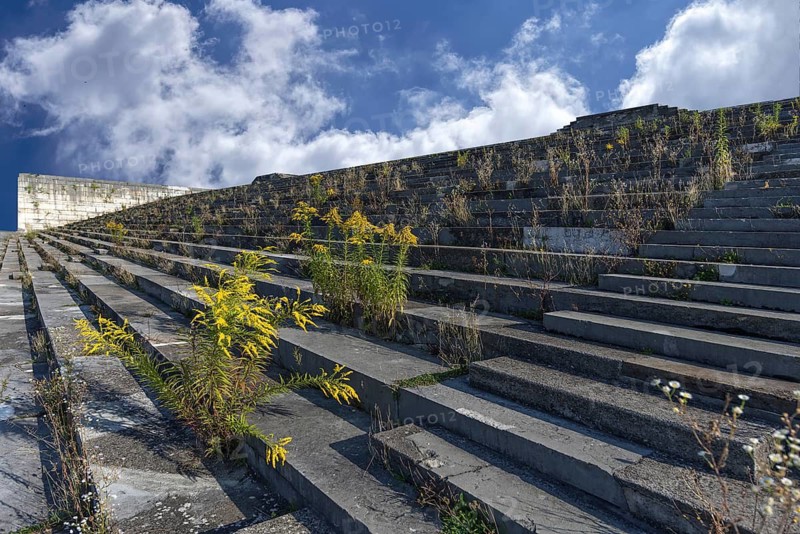 Wild plants grow on the main stand of the Zeppelin field on the former Reichsparteitagsgelände, Wolkenhimmel, Nuremberg, Middle Franconia, Bavaria, Germany