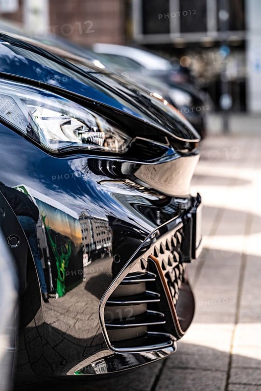 Close-up of shiny front of a black car in an urban environment, Deer, e-carsharing, Stuttgart, Germany