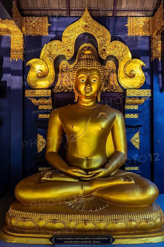 Seated gilded Buddha statue in the Buddhist temple Wat Phra That Don Phra Chan, near Lampang, Lampang Province, Thailand