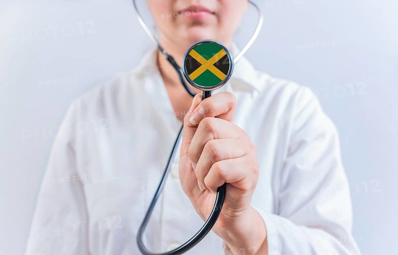 Female doctor holding stethoscope with Jamaica flag. National health system of Jamaica