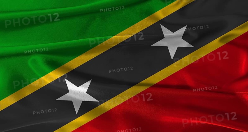 Flag of Saint Kitts and Nevis with fabric textured background. Close up of National flag of Saint Kitts and Nevis with realistic texture