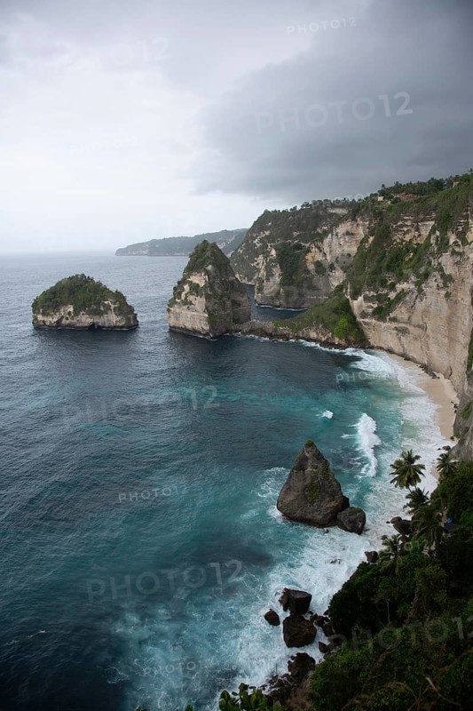 Impressive coastal scenery with distinctive cliffs and stormy seas under cloudy sky, Diamond Beach, Nusa Penida, Bali Indonesia