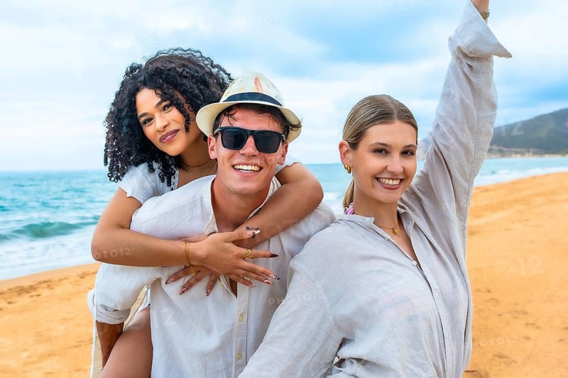 Group of diverse friends celebrating happiness and freedom while playing together on a tropical beach, sharing laughter and positive emotions during their summer holiday
