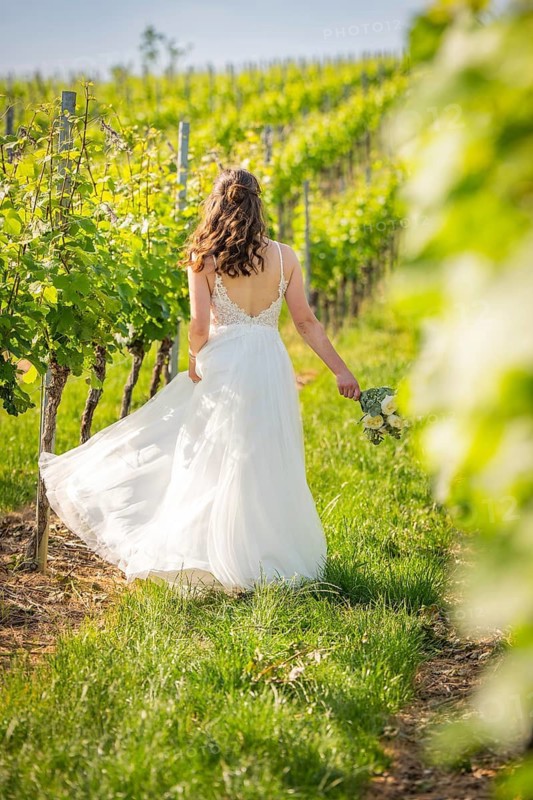Bride moving along vines holding flower bouquet, wedding, Grossglattbach, Germany
