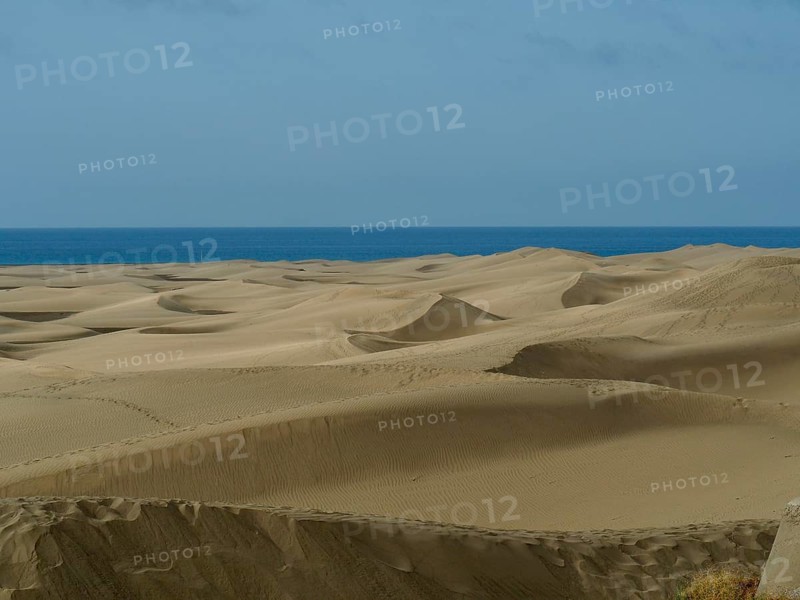 Extensive dune landscape down to the sea under slightly cloudy sky, dunes of Maspalomas, Gran Canaria, Spain