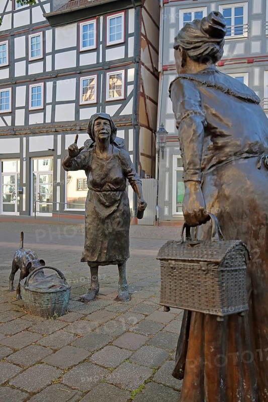 Market Women sculpture by Ewald Rumpf 2009, modern art, bronze sculpture, life-size, two standing woman with index finger, gesture, arm up, gossip, chatter, listening, telling, communication, marketplace, Rotenburg an der Fulda, Hesse, Germany