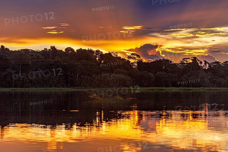 Dramatic sunset with clouds over a river in the Amazon, sunset on the Beni River near Rurrenabaque in the Amazon basin in Bolivia