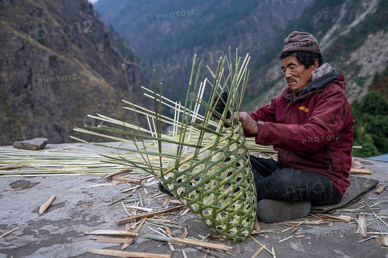 Nepalese, local of the Tsumba Tibetan ethnic group weaving a basket, traditional crafts, Tsum Valley, Himalayas, Nepal