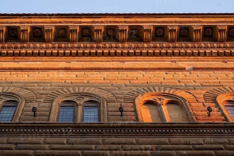 Façade of Palazzo Strozzi with intricately crafted roof cornice, warm evening light, old town, Florence, Tuscany, Italy