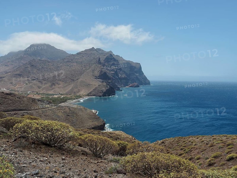 Wide coastline with rocky hills and views of the sparkling blue sea, La Aldea de San Nicolas, Gran Canaria, Spain