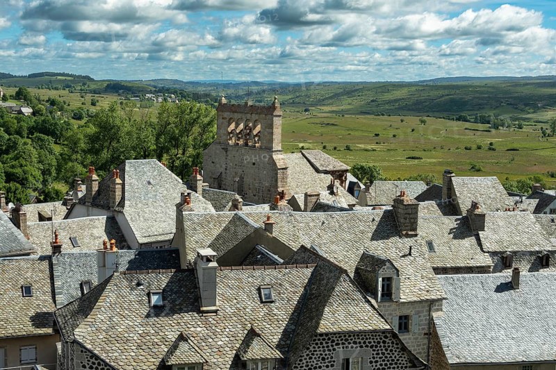 Saint Urcize. Aubrac Regional Natural Park. View of the village and the Romanesque church of Saint-Pierre and Saint-Michel with its comb-shaped bell tower. Cantal department. Auvergne Rhone Alpes. France