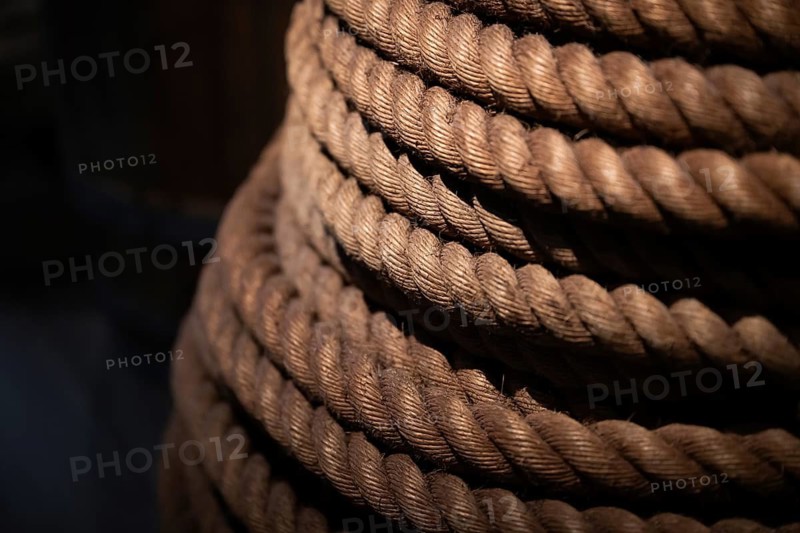 Close-up, thick rope layered on top of each other, illuminated in contrast between light and shadow, Strandingsmuseum St. George, North Sea coast, Thorsminde, Denmark