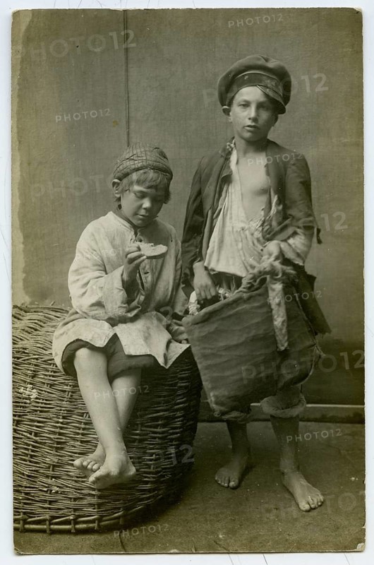 Jewish children, beggars, Vilnius, Lithuania, poverty, poverty, orphans, barefoot, two boys in poor clothes posing with a large basket in a simple room