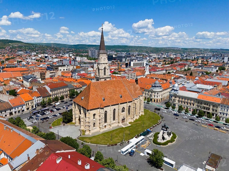 Historic church with red roof in urban landscape under blue sky, aerial view, St. Michael's Church in Cluj, Gothic hall church, statue of Matthias Corvinus, Cluj-Napoca, Cluj, Transylvania, Transylvania, Transylvania region, Romania