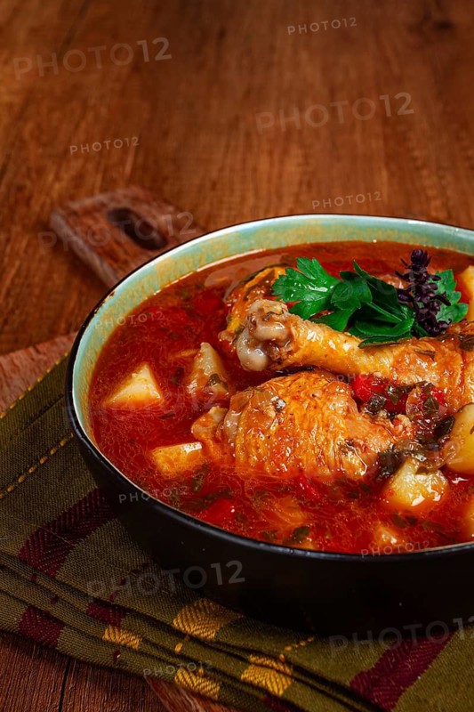 Souzi soup. Georgian dish, meat with oats, tomato sauce and herbs, on a wooden table