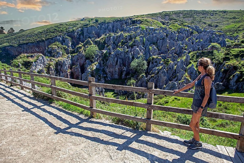 Middle aged woman contemplates the Buferrera mines at the Covadonga lakes ensemble, Picos de Europa National Park, principality of Asturias, Spain