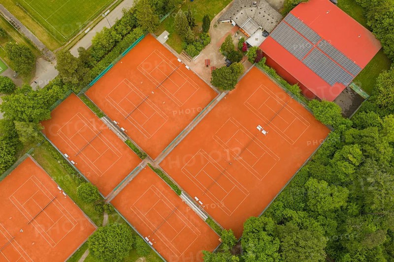 Tennis courts with orange sand in an organized sports complex, surrounded by buildings and nature, taken from the air, Aidlingen sports field, Böblingen district, Germany