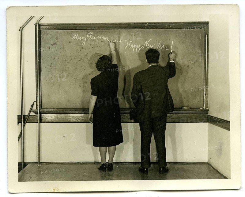 Teacher, school blackboard, Happy New Year, Merry Christmas, New Year Greetings, Christmas, Humor, Two people write holiday greetings on a blackboard in a simple room, around 1955